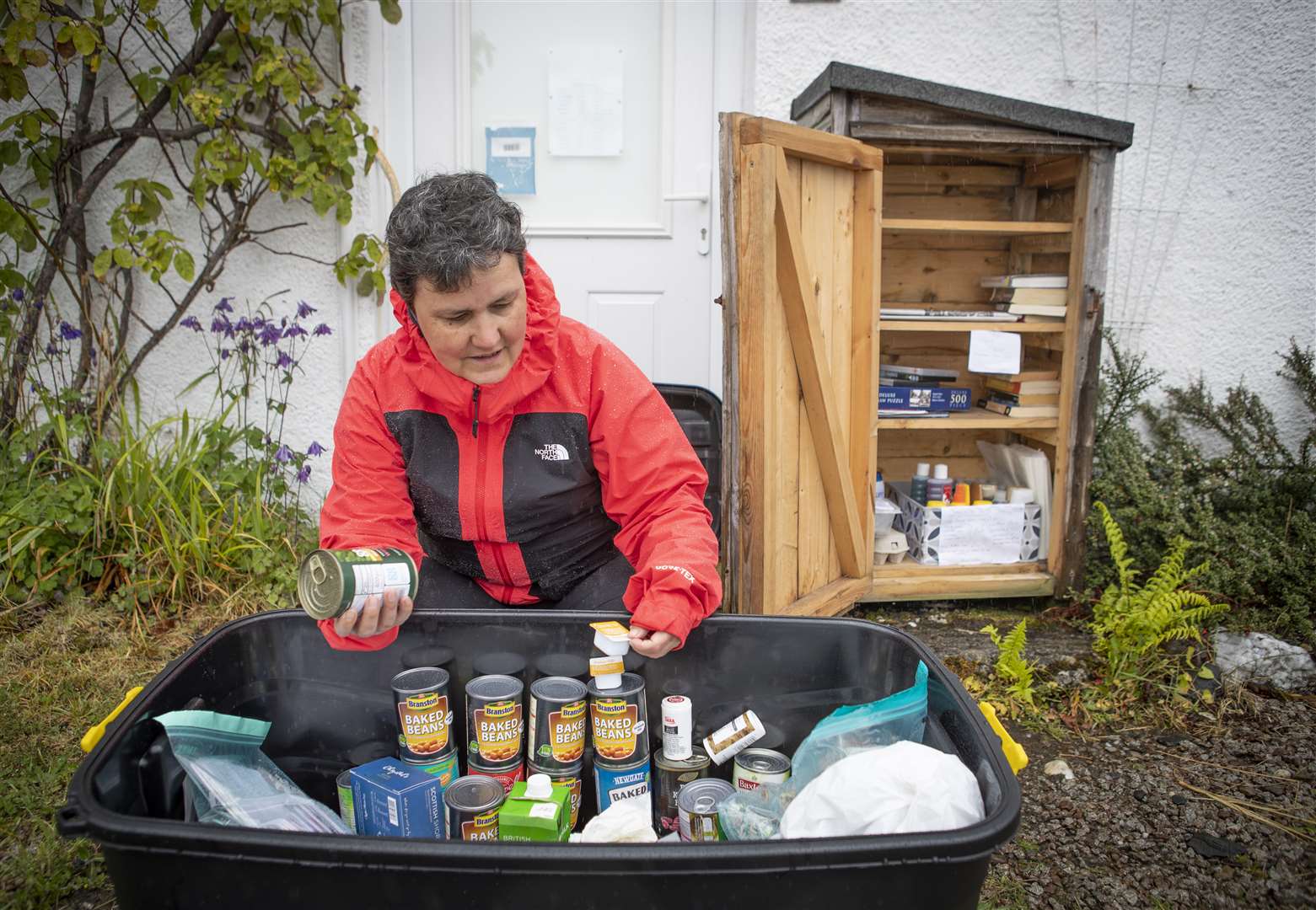 Becs Barker checks the donations left in the “swap shop” box (Jane Barlow/PA)