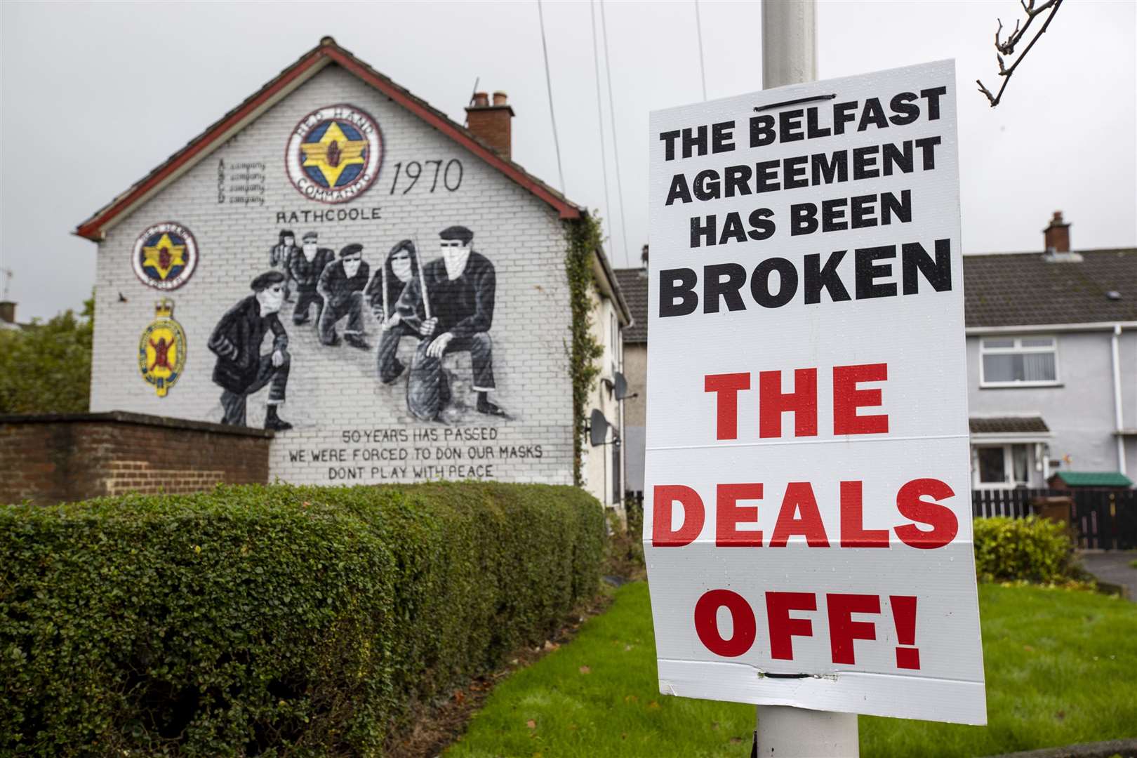 A sign on a lamppost in the Rathcoole housing estate of Newtownabbey, County Antrim, Northern Ireland with a mural to the Red Hand Commando (RHC) a secretive Ulster loyalist paramilitary group (Liam McBurney/PA)