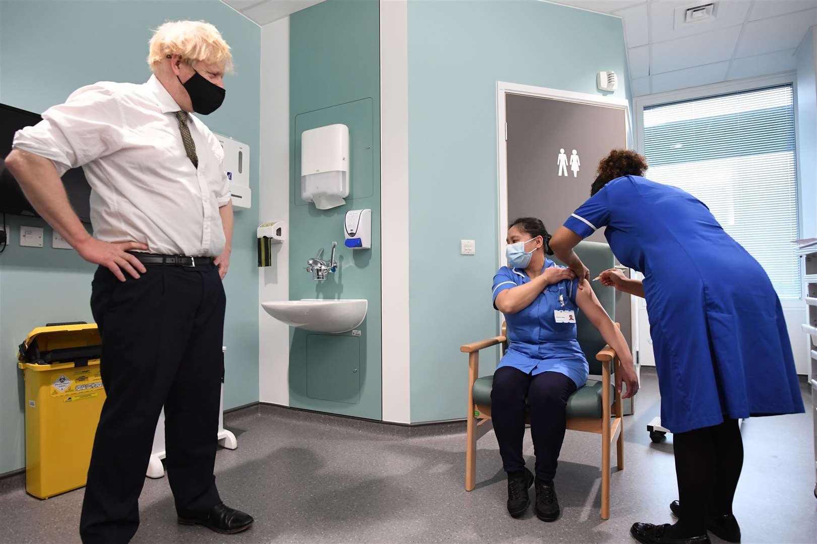 Prime Minister Boris Johnson watches as Jennifer Dumasi is injected with the Oxford/AstraZeneca Covid-19 vaccine during a visit to Chase Farm Hospital in north London (Stefan Rousseau/PA)