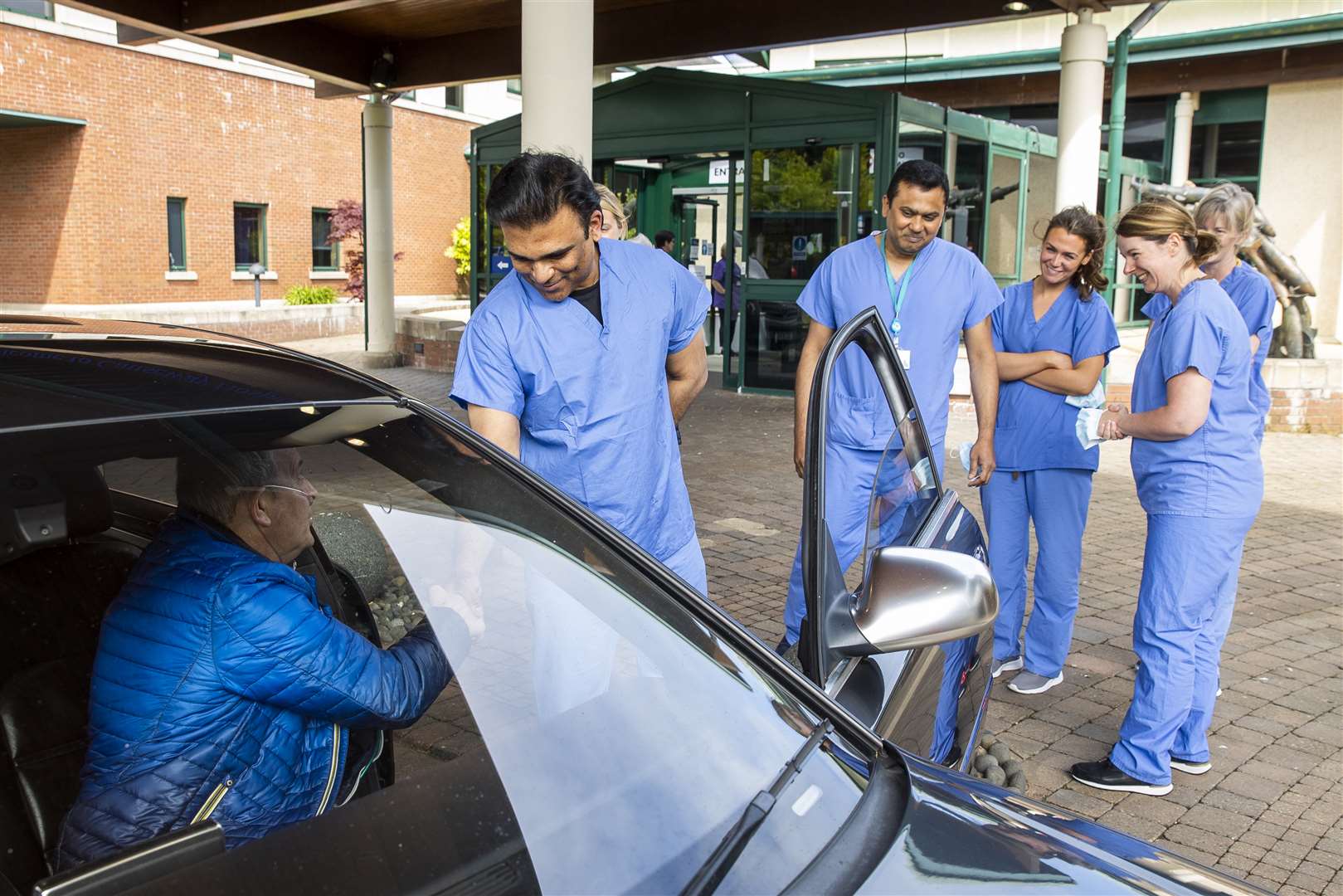 Geoffrey McKillop (sitting in car) shakes the hand of a member of his care team (Liam McBurney/PA)