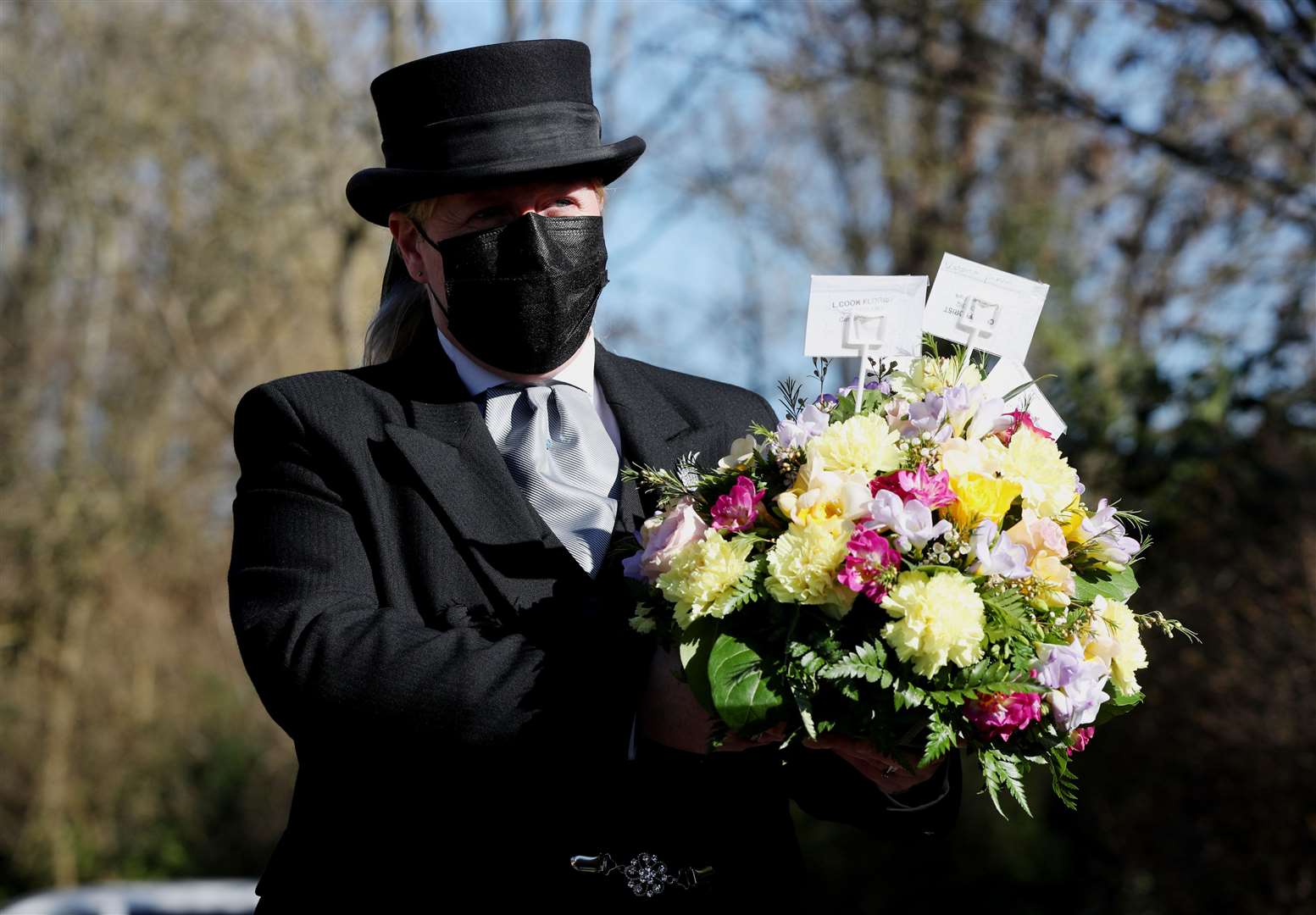 Funeral director Colette Sworn gathers a floral tribute as part of her preparations to oversee a funeral at Co-op Funeralcare in Watford, Hertfordshire (Jonathan Brady/PA)