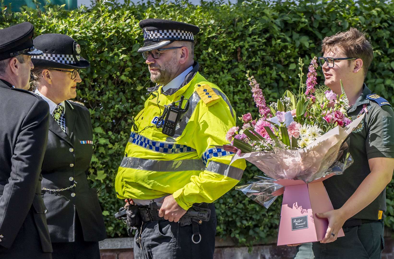 Merseyside Police Chief Constable Serena Kennedy (second left) looks on as a paramedic carries flowers (Danny Lawson/PA)