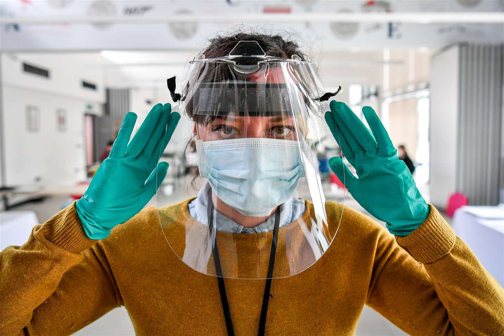 A Royal Mint employee checks the fit of a full-face visor (Ben Birchall/PA)