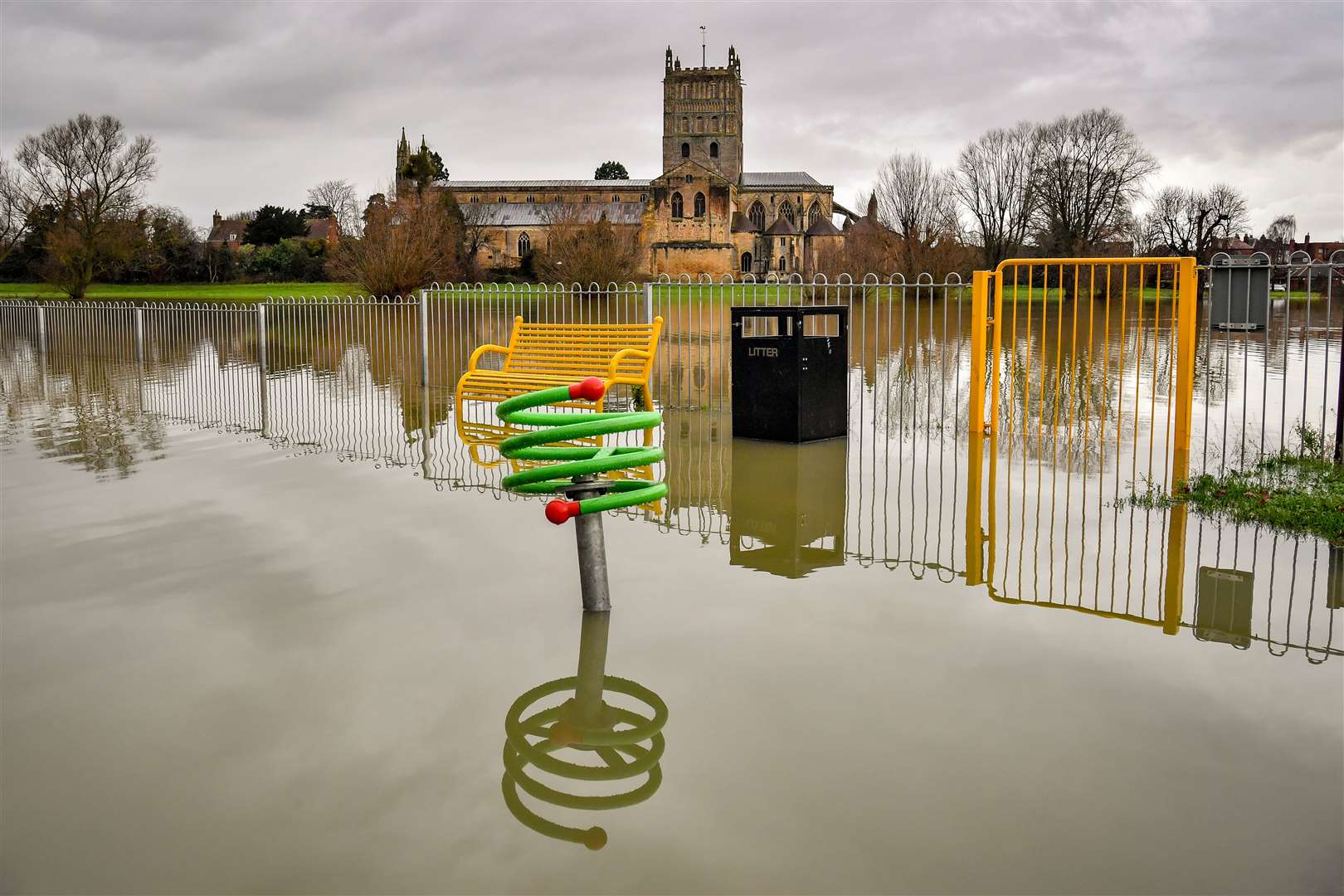 Children’s playground equipment pokes out from floodwater surrounding Tewkesbury Abbey after heavy rain prior to Christmas (Ben Birchall/PA)