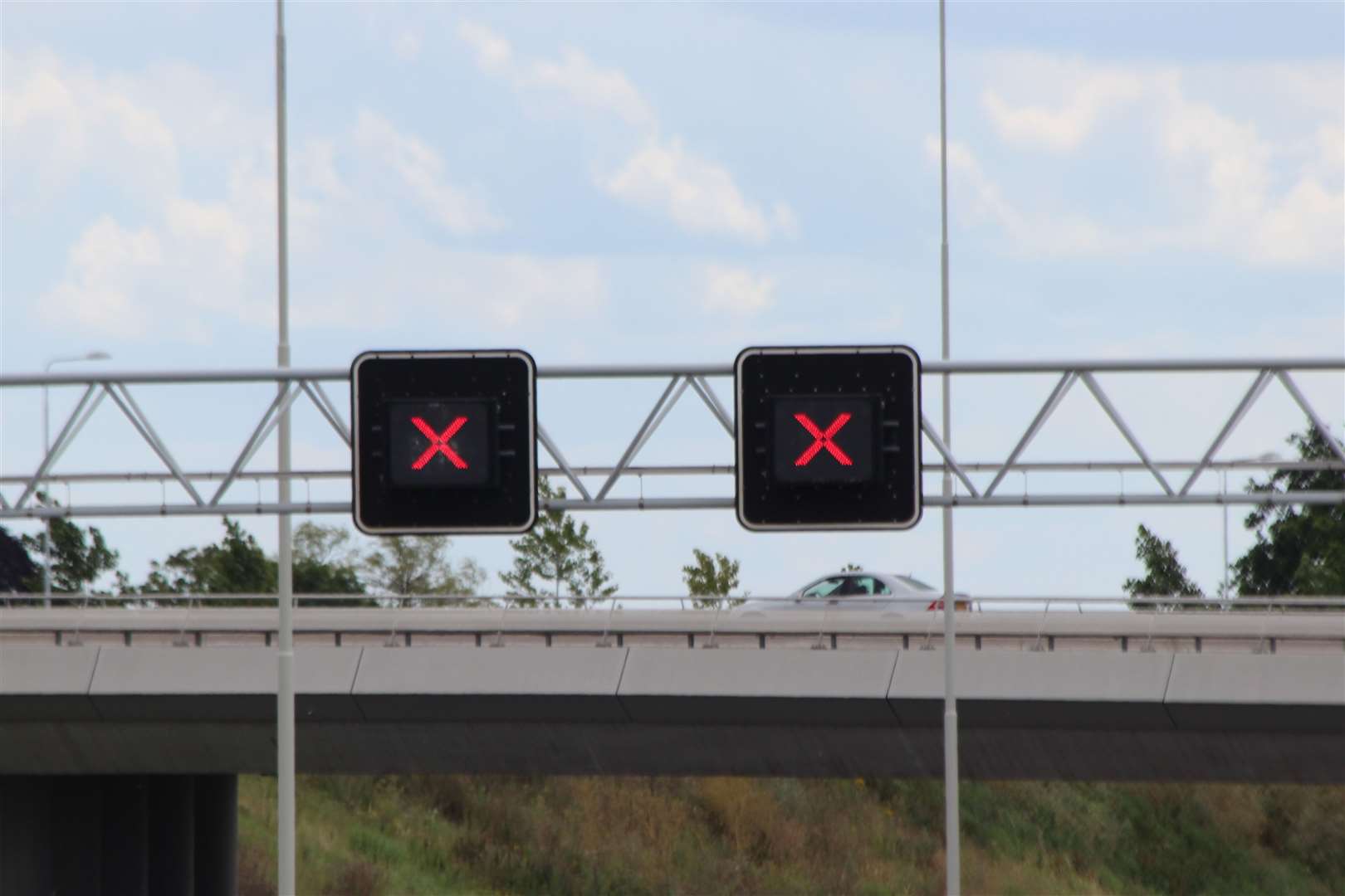 Red crosses above driving lanes on motorways tell drivers the lane is closed and to move across