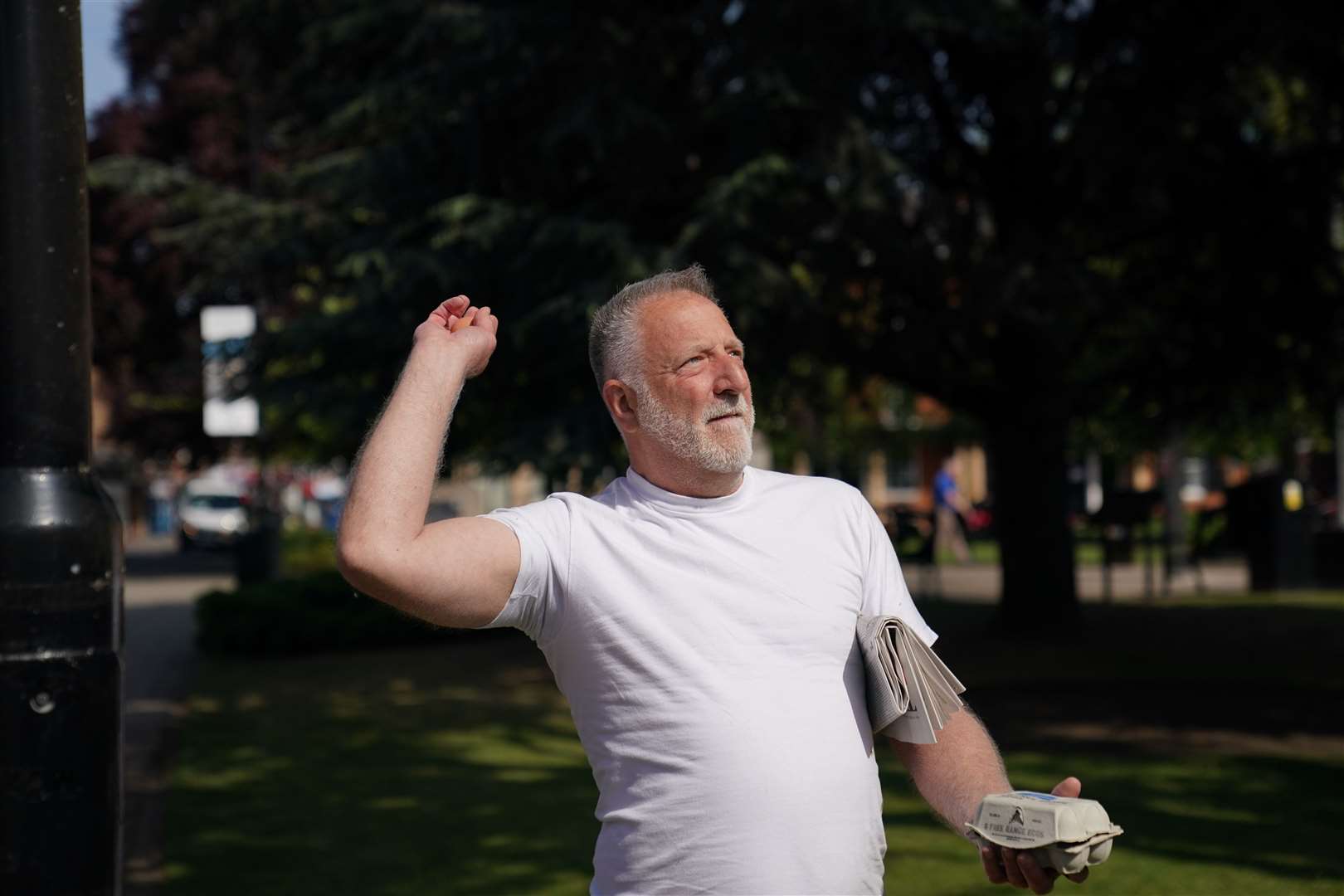 A man in a white t-shirt throws eggs at a statue of Baroness Thatcher (Joe Giddens/PA)