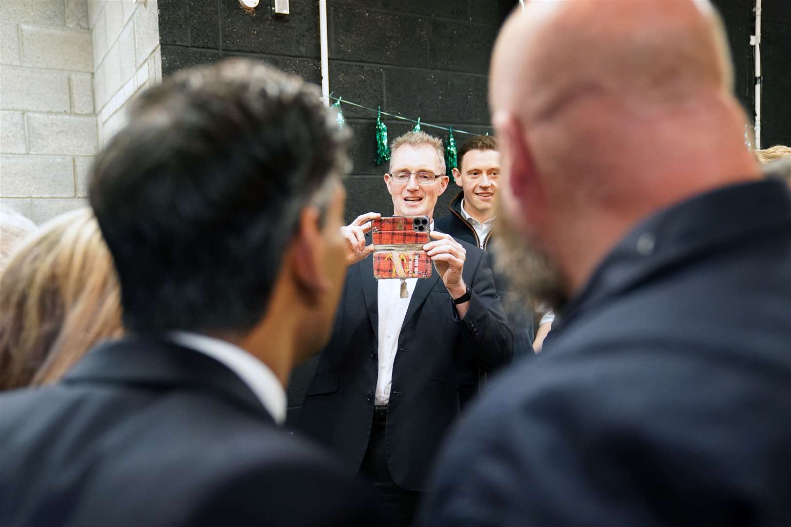 Welsh Secretary David TC Davies takes a photo of Rishi Sunak at the Vale of Glamorgan Brewery, in Barry, where the teetotal Prime Minister made a gaffe by asking if the football this summer would boost sales, despite Wales not qualifying for the Euro 2024 tournament (Stefan Rousseau/PA)