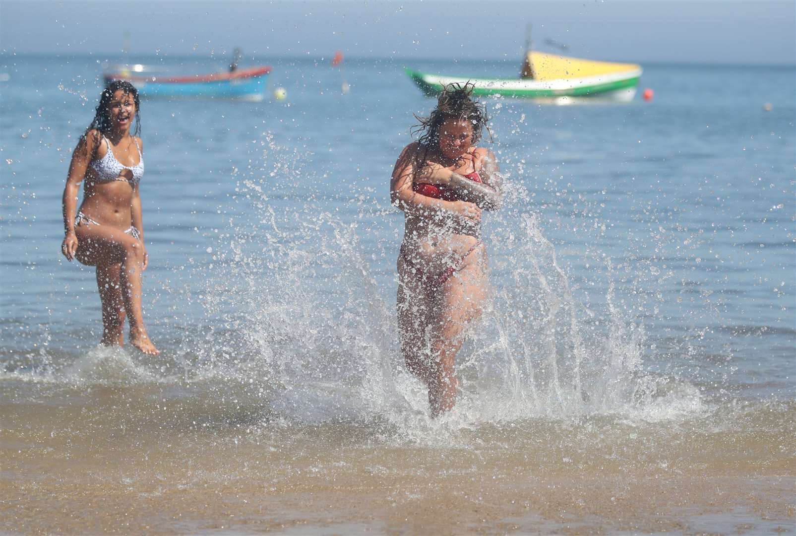 Sorrell Vince, 23 (right) from Northampton and Bethany Heatley from Preston enjoying the sun on Cullercoats Beach, Tynemouth (Owen Humphreys/PA)