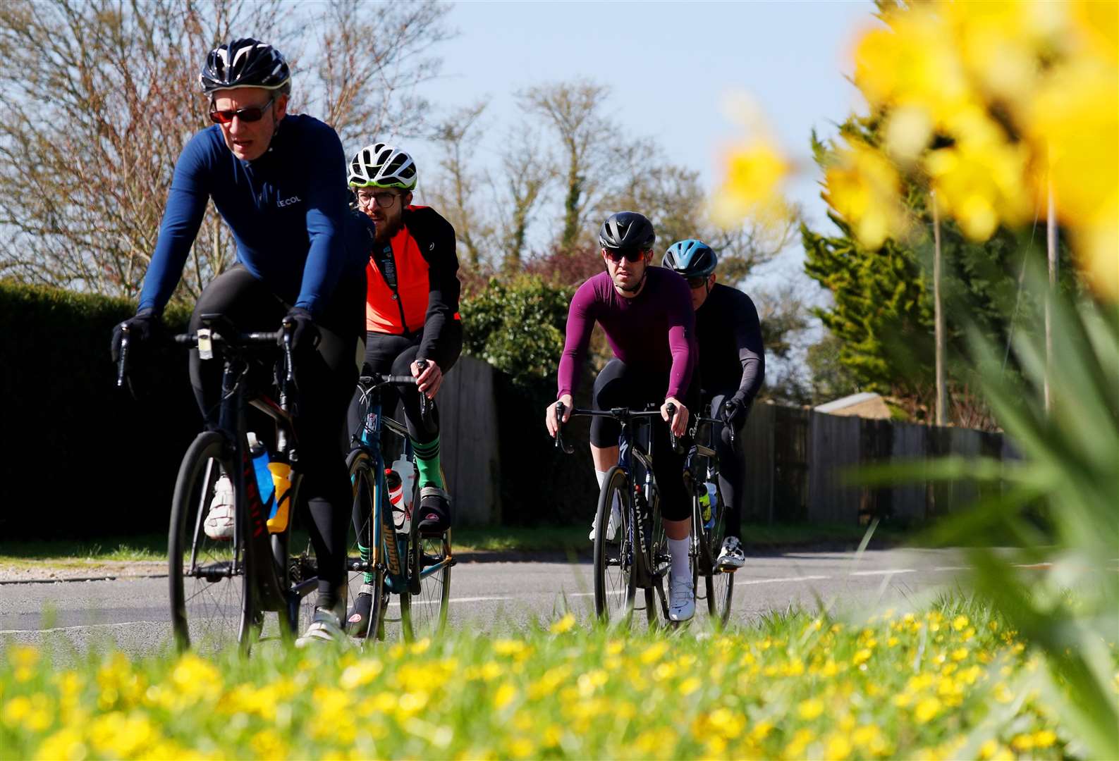 Cyclists pass a bank of daffodils in Paley Street, Berkshire (Jonathan Brady/PA)