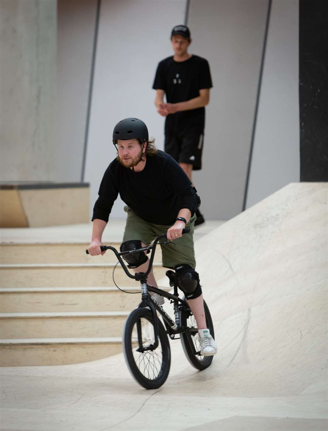 Coach Chris Bradley keeps a watchful eye on reporter Rhys Griffiths as he tries his hand at BMX. Picture: Andy Jones