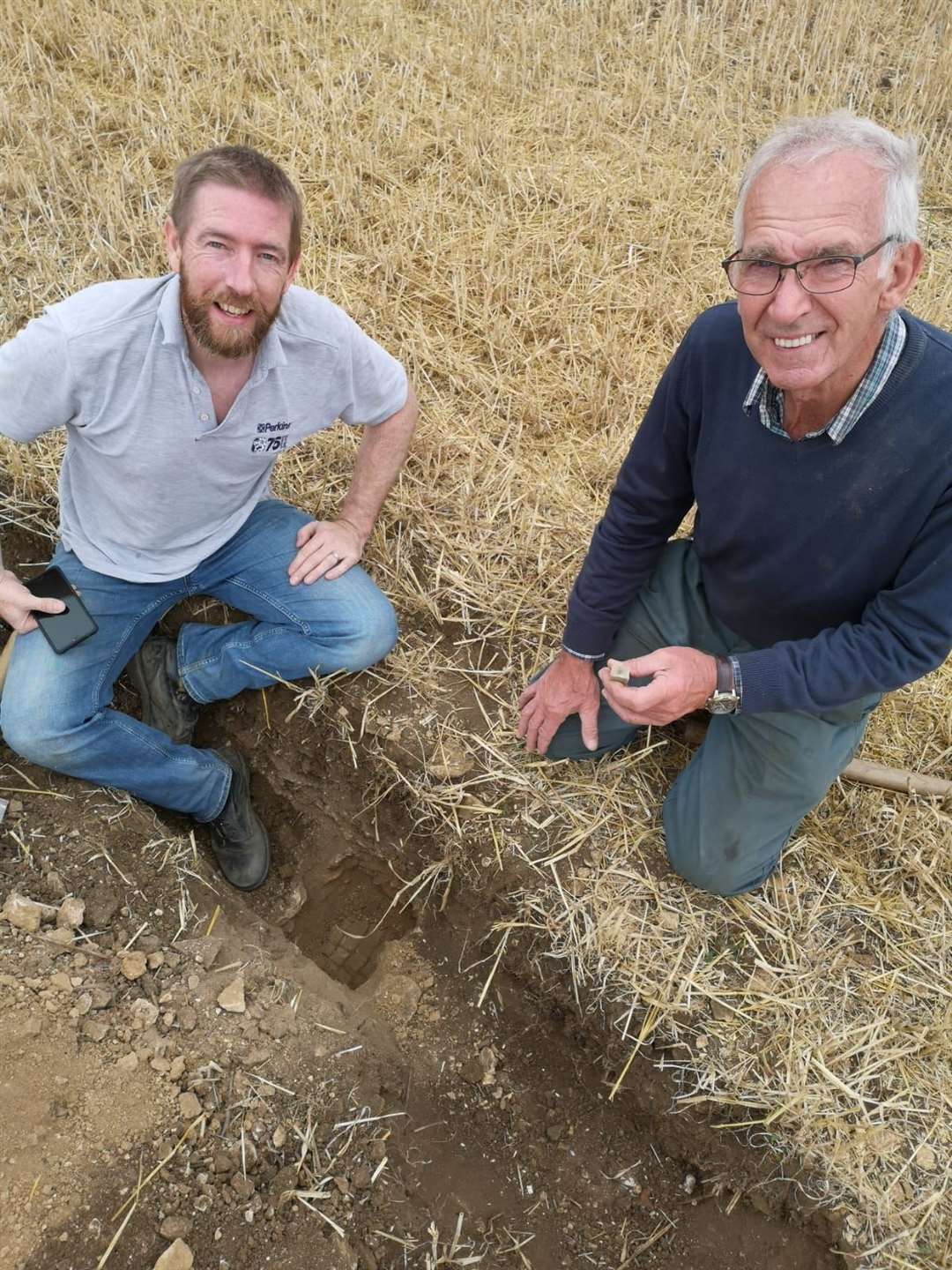 Jim Irvine, who discovered the site, with his father Brian Naylor, who owns the land on which the mosaic was found (University of Leicester Archaeological Services/PA)