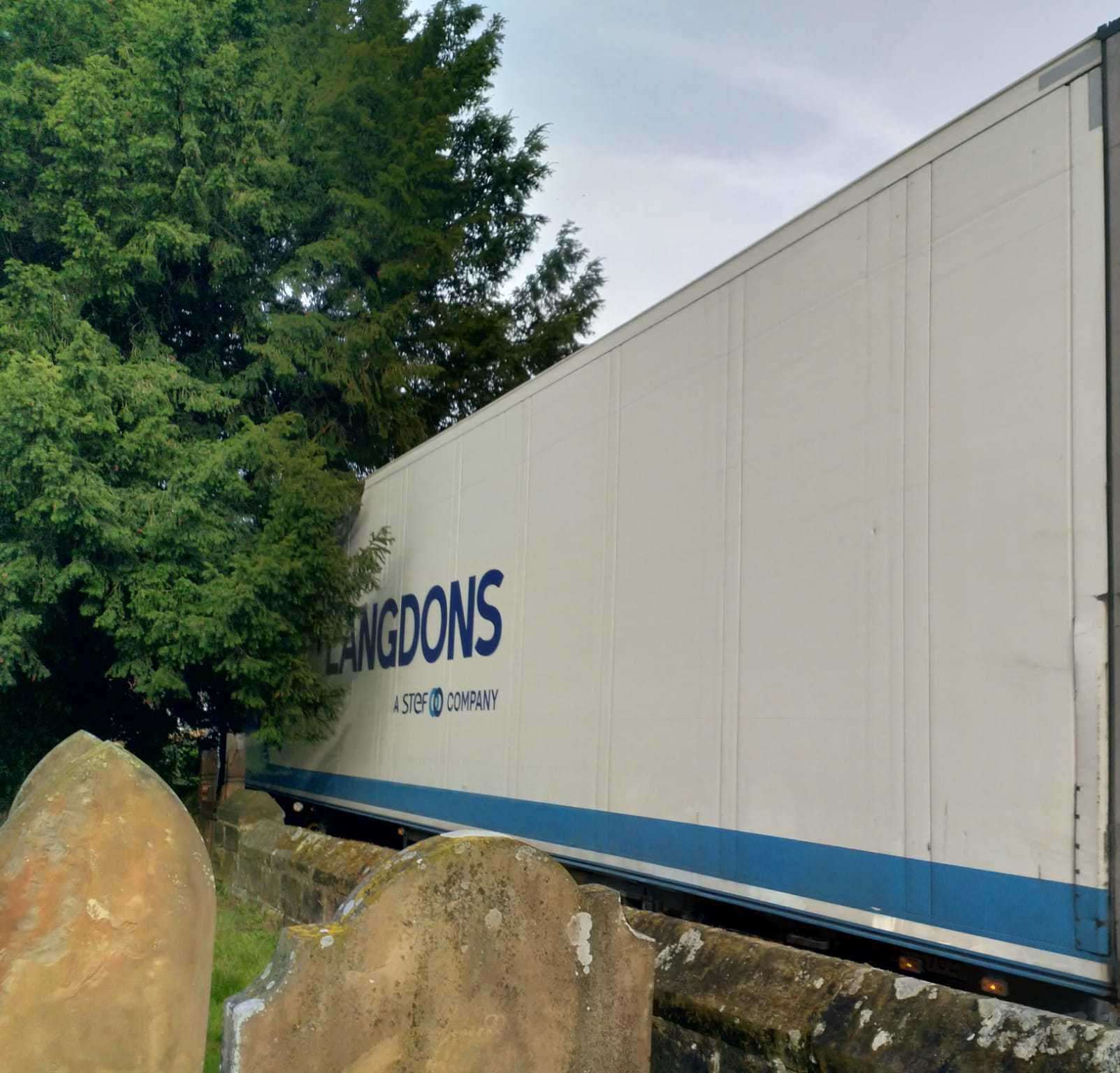 A lorry rumbles by close to the wall at St Mary's Church in Goudhurst