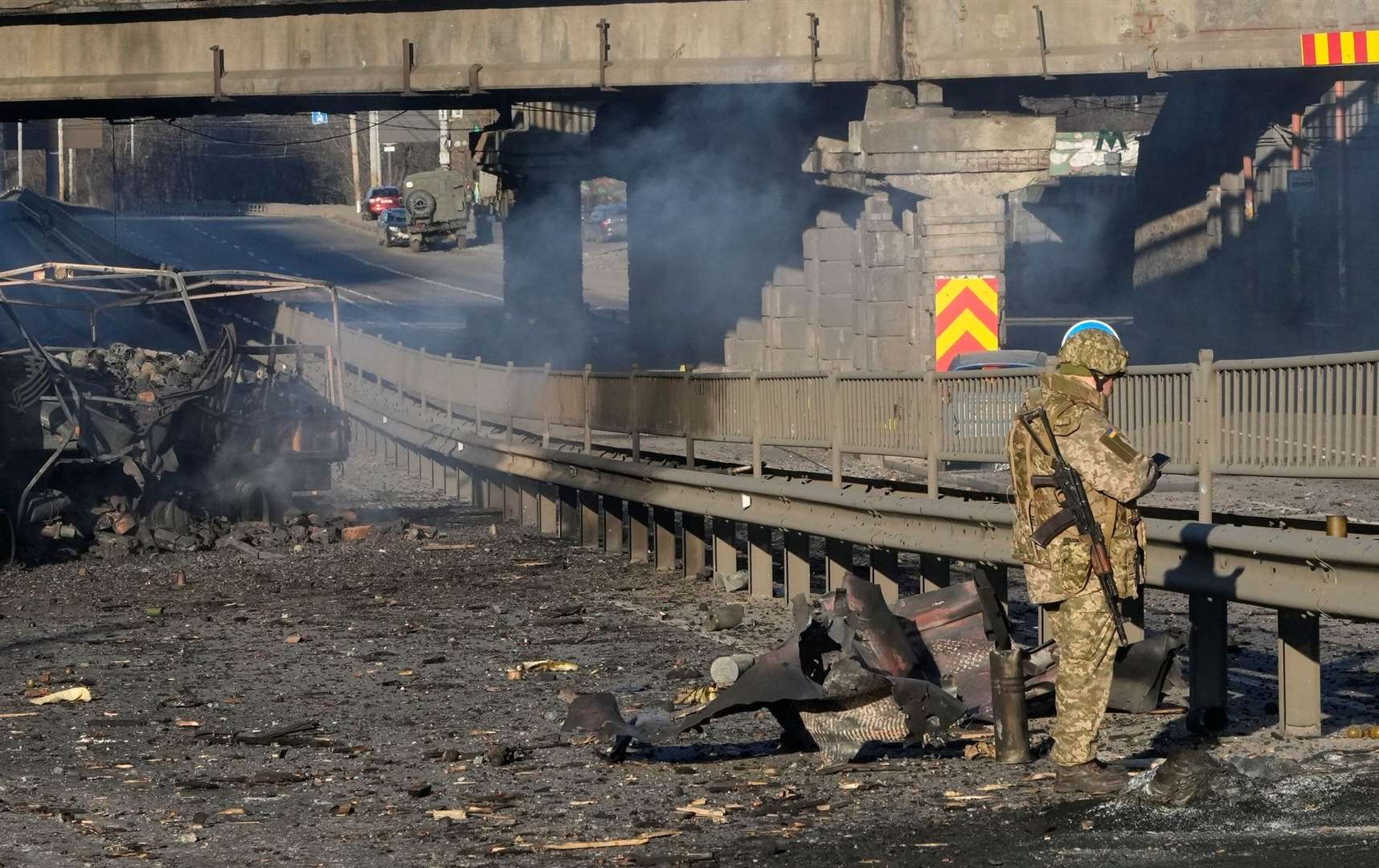 A Ukrainian soldier investigates debris of a burnt military truck in a street in Kyiv. Picture: Efrem Lukatsky/AP