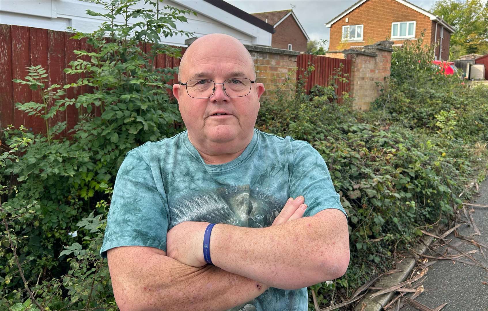 Mr Baynes says he is 'sick and tired' of seeing the overgrown weeds outside his home in Ashford