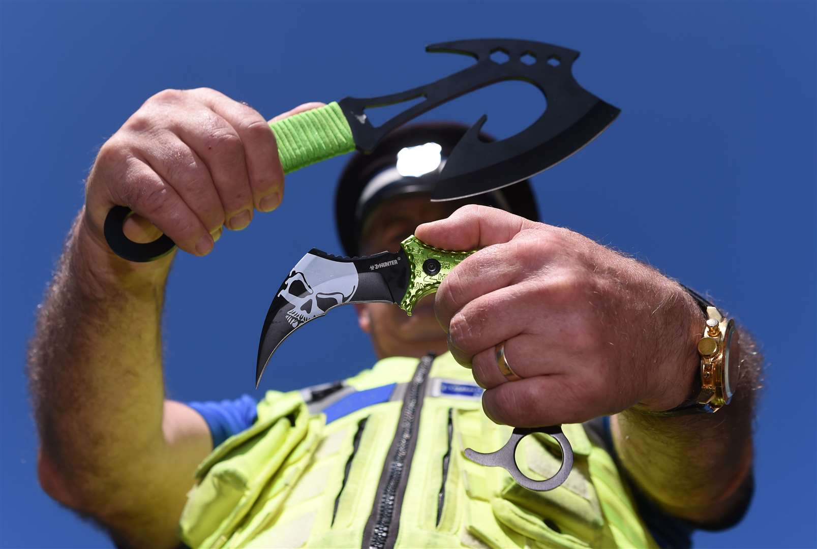 A police officer holds two examples of zombie knives (PA)