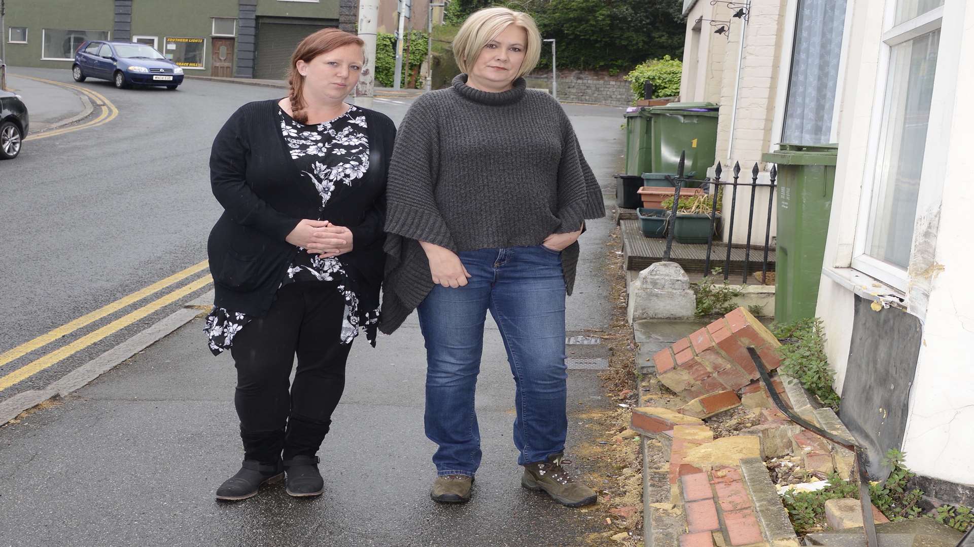 Tracy Salisbury by the wall infront of her house that was demolished by a car with neighbour Sammy Rawlings. Picture: Paul Amos