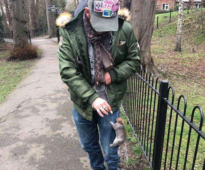 Wayne Taylor feeding a squirrel monkey nuts.