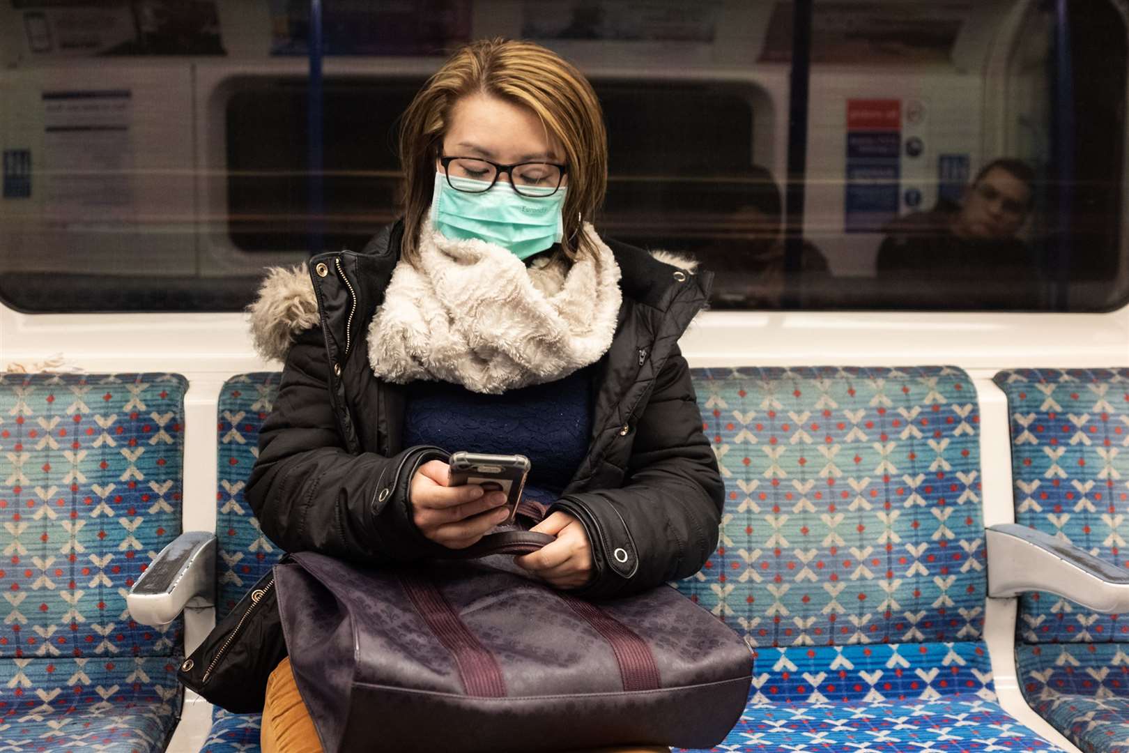 A woman in a face mask rides the Tube (Ian Hinchcliffe/PA)