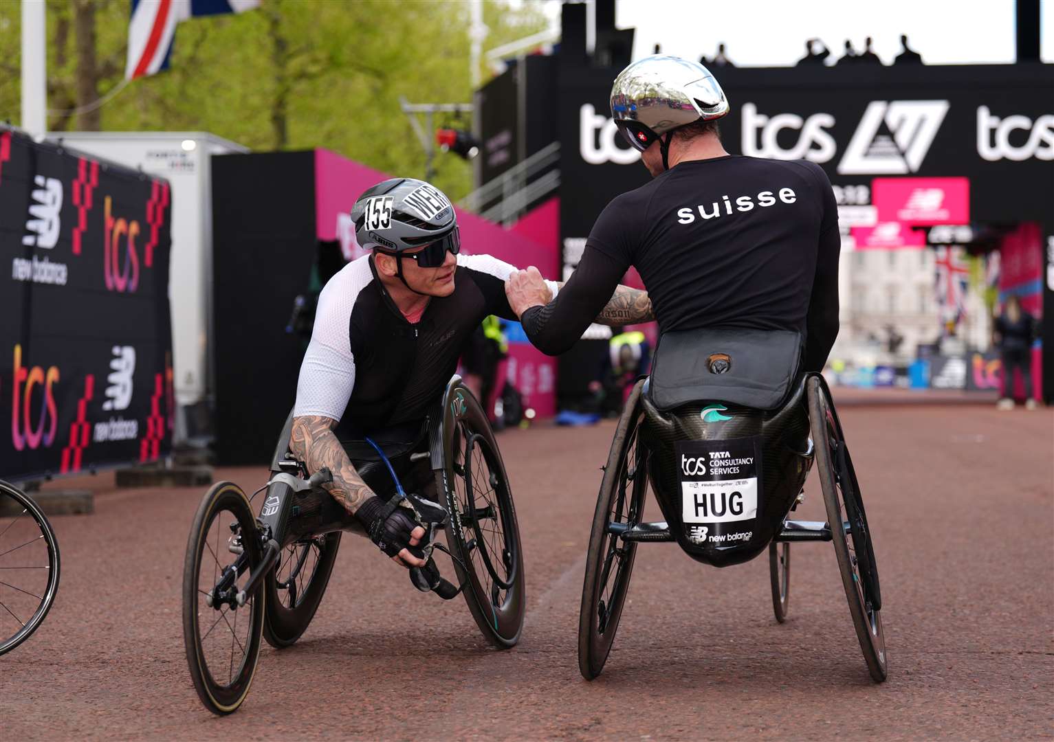 Third place David Weir congratulates Marcel Hug on winning the men’s wheelchair race during the TCS London Marathon (John Walton/PA)