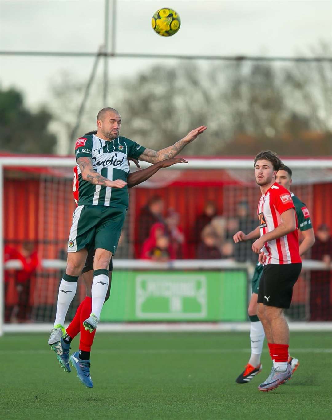 Ashford United midfielder James Dunne wins a header at Sheppey. Picture: Ian Scammell