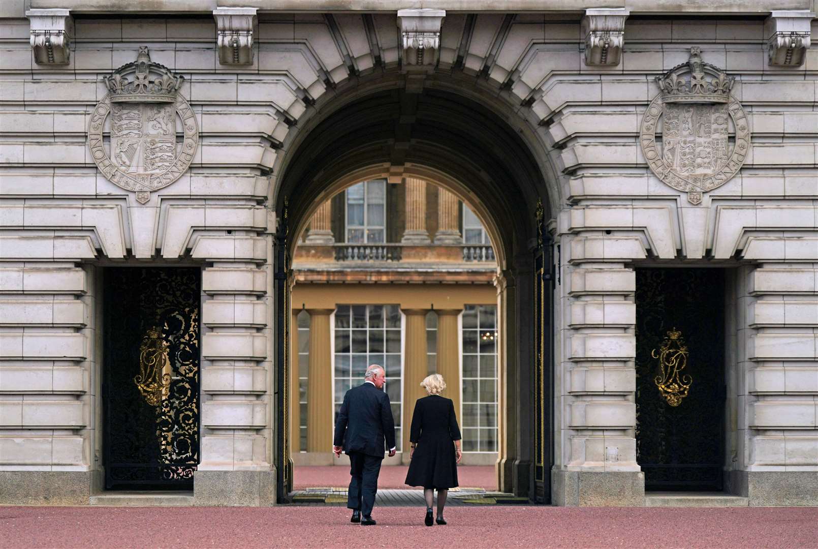 King Charles III and the Queen walk into Buckingham Palace for the first time as monarch and consort (Yui Mok/PA)