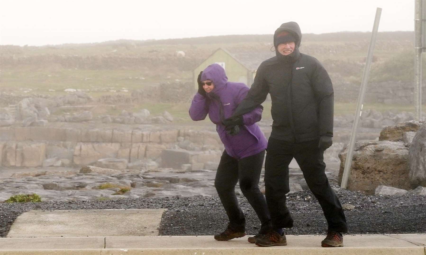 People brave high winds in Doolin in County Clare on the west coast of Ireland (Niall Carson/PA)