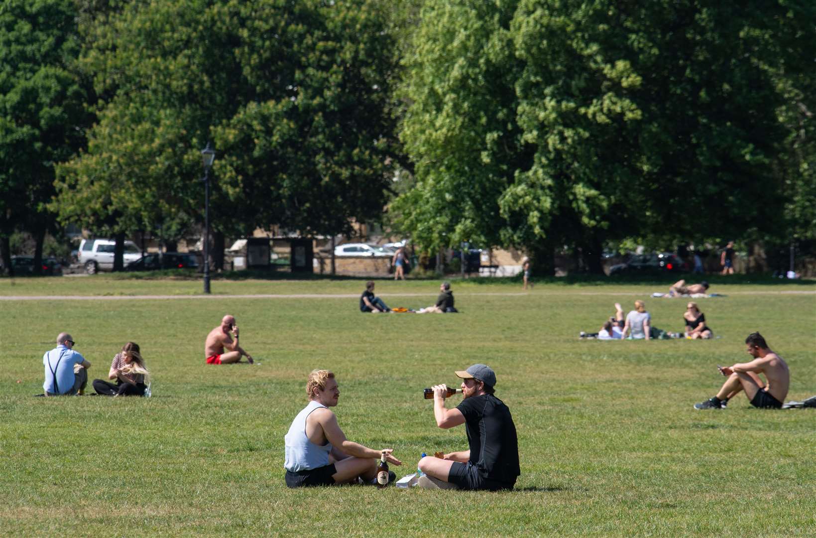 People observe social- distancing advice as they enjoy the hot weather on Clapham Common, London (Dominic Lipinski/PA)