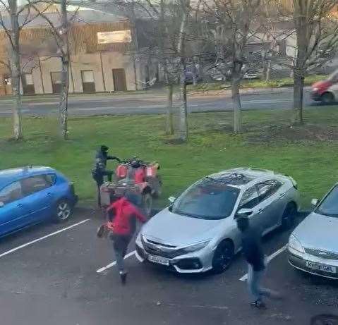 Running away: the thugs made a dash followed by the quad bike's owner outside a Sittingbourne factory.