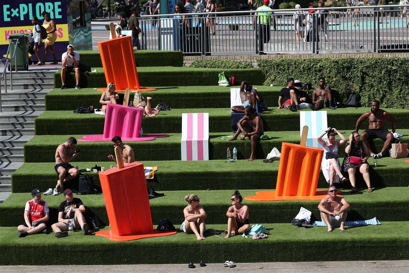 People sunbathing on the steps near Granary Square, at King’s Cross, London (Jonathan Brady/PA)