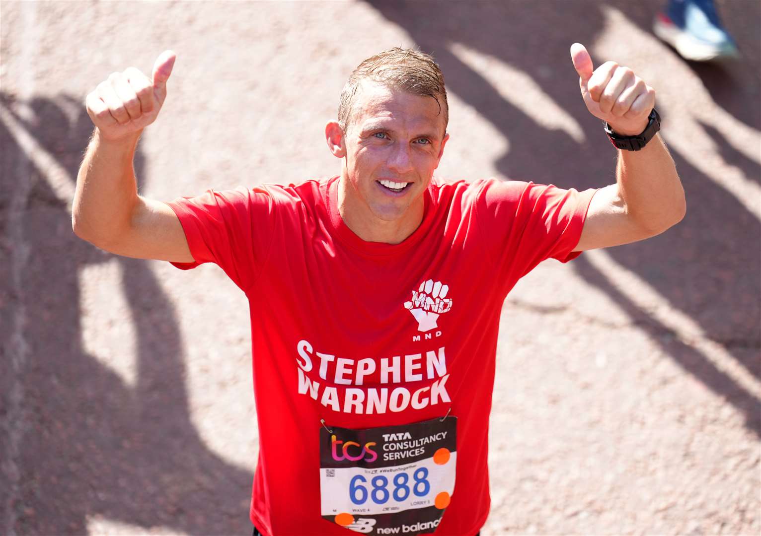 Stephen Warnock celebrates completing the marathon (John Walton/PA)