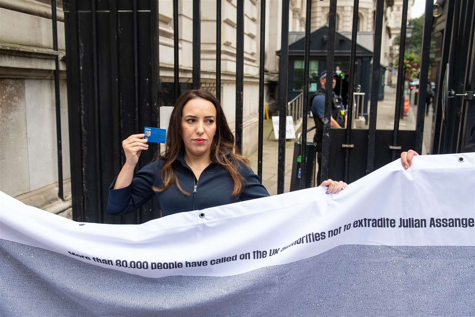 Stella Moris holds up a Julian Assange press card outside the gates of Downing Street (Dominic Lipinski/PA)