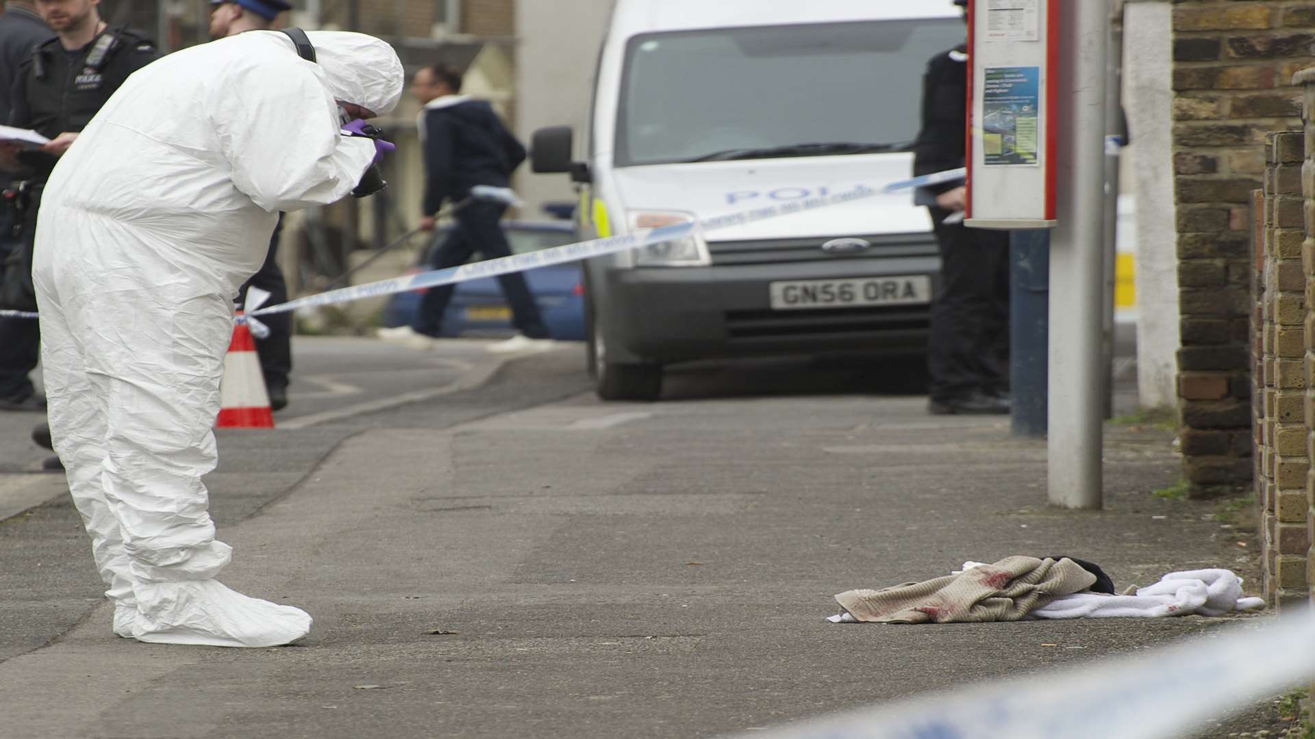 A Police forensics officer gathers evidence at the crime scene in Milton Road, Gravesend.