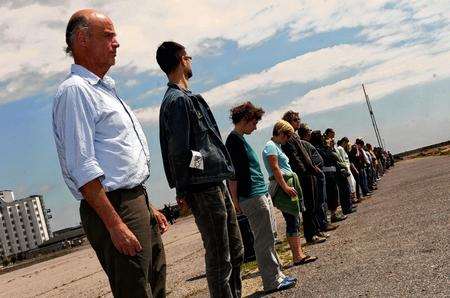 Artist Hamish Fulton, left, leads a line of people walking slowly towards the sea at last year's Folkestone Triennial