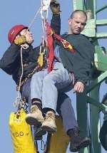 ALMOST SAFE: Kirk Hayes being lowered with the help of leading firefighter Paul Evans from Deal. Picture: MATT READING