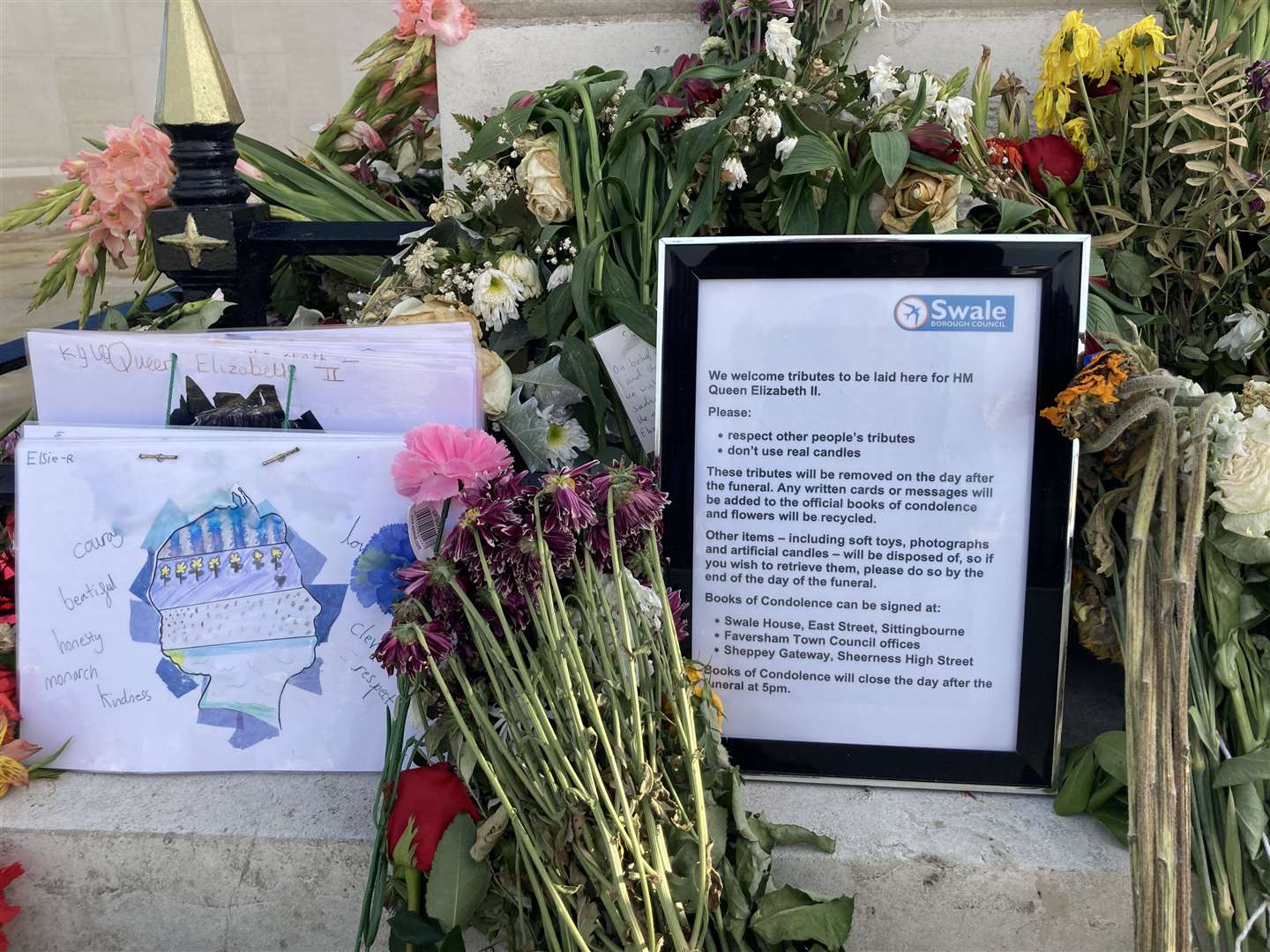 Floral tributes left at the base of the war memorial in Sheerness to mark the death of The Queen. Picture: John Nurden