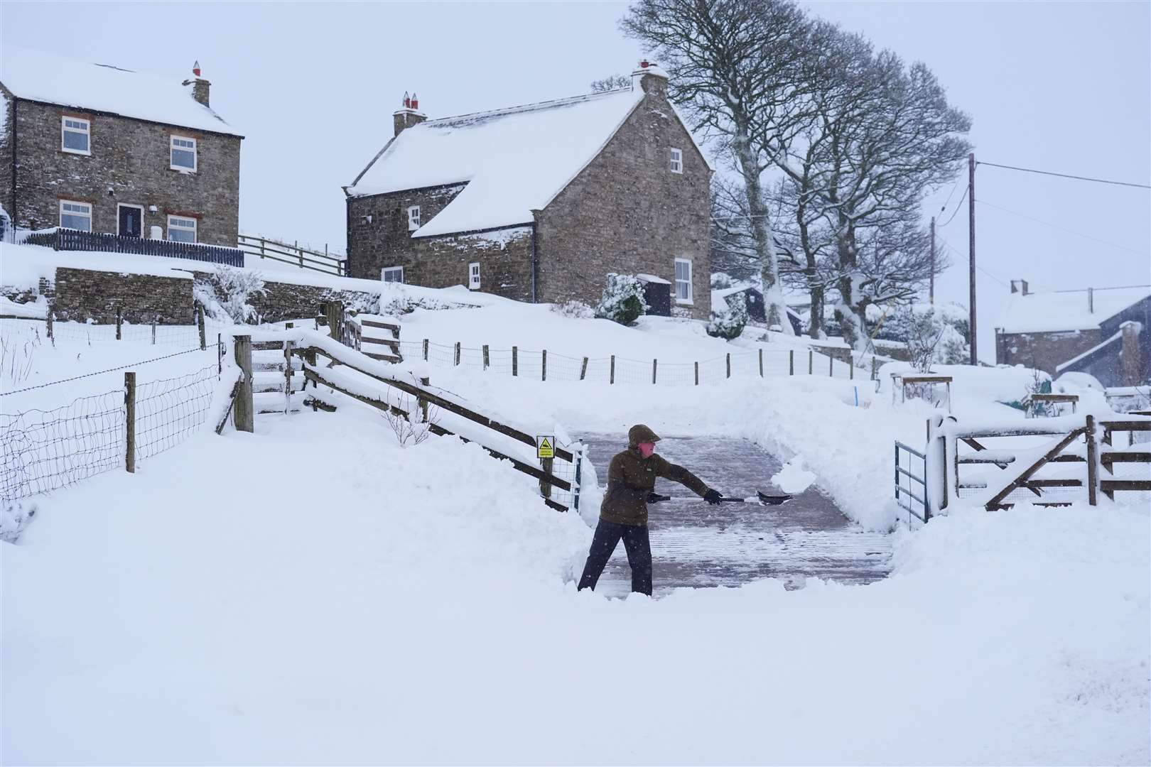 A man clears snow near Allenheads (Owen Humphreys/PA)