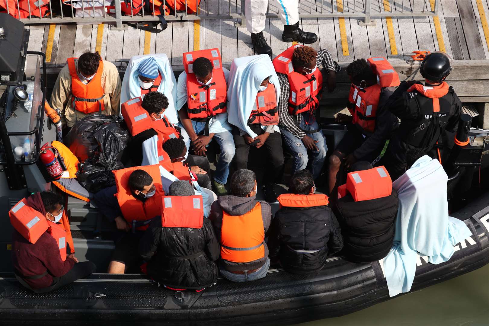 A group of people, thought to be migrants, waiting on Border Force (Gareth Fuller/PA)