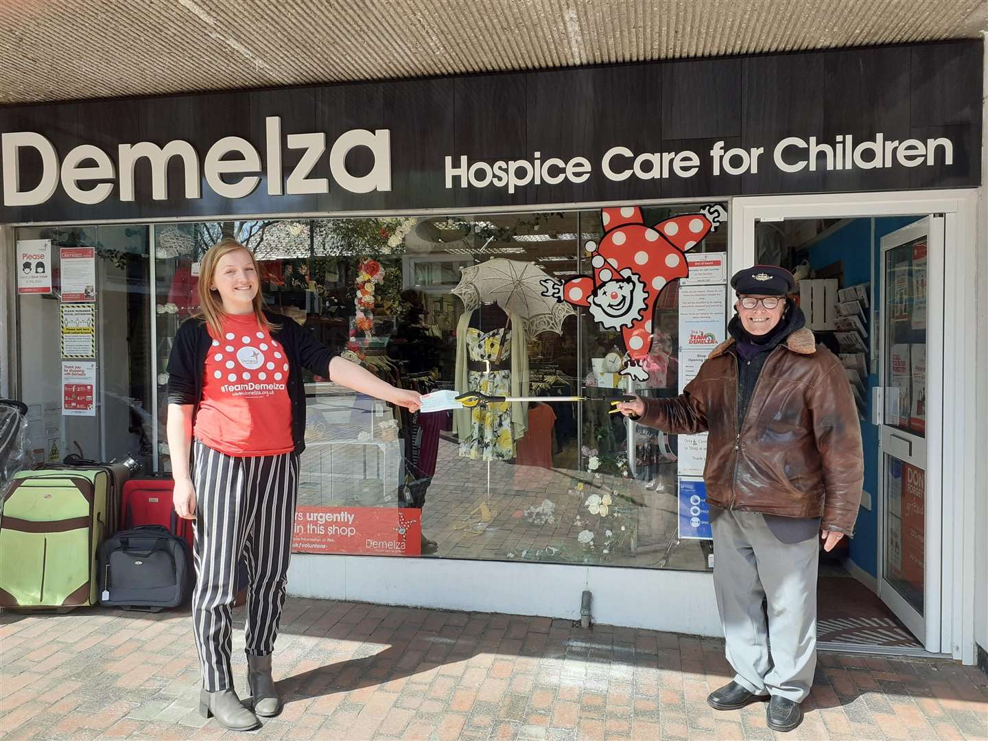 Demelza Hospice Care for Children’s community fundraising executive Claire Battersby is presented with a cheque for the 'stolen' £50 from Sittingbourne's 'whistling postman' Dale Howting in Roman Square