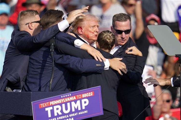 Former president Donald Trump is helped off the stage at a campaign event. Picture: Gene J Puskar/AP