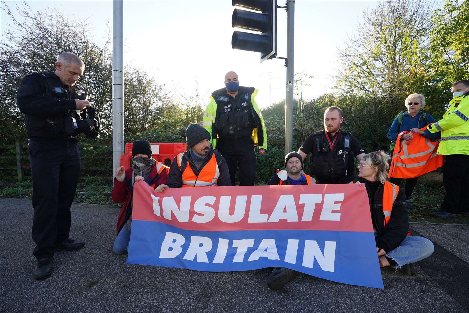 Police speak to protesters at the junction of the M25 and the A1 (Ian West/PA)