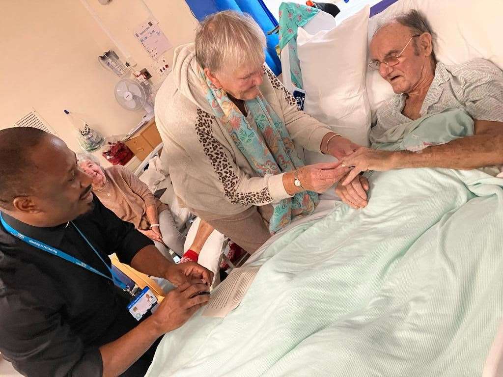 Carole Thomas places the ring on husband Gerald's finger watched by hospital chaplain Chinedu Udonsi