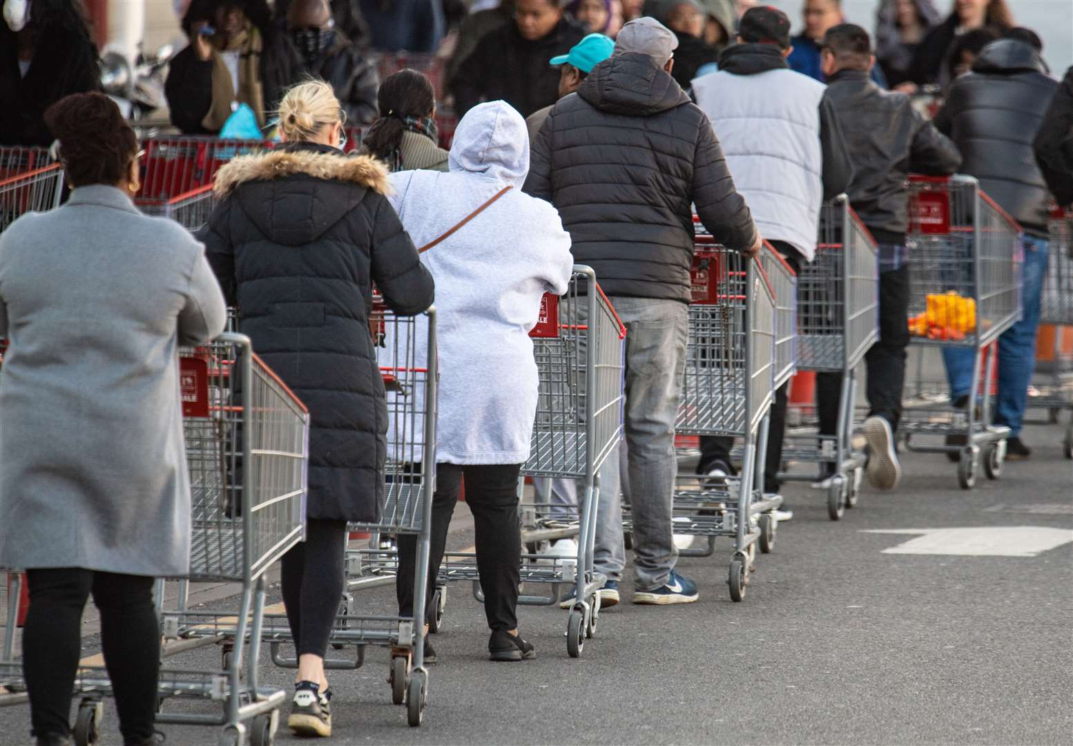 Supermarkets have remained open throughout lockdown, with long queues outside (Dominic Lipinski/PA)