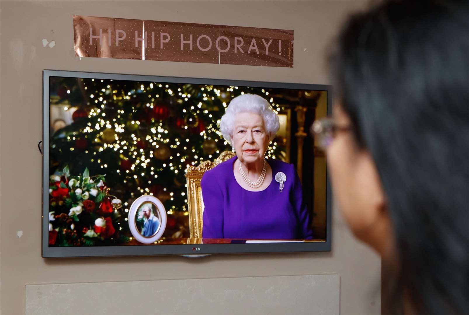 A woman watches the Queen’s Christmas Day speech (Danny Lawson/PA)