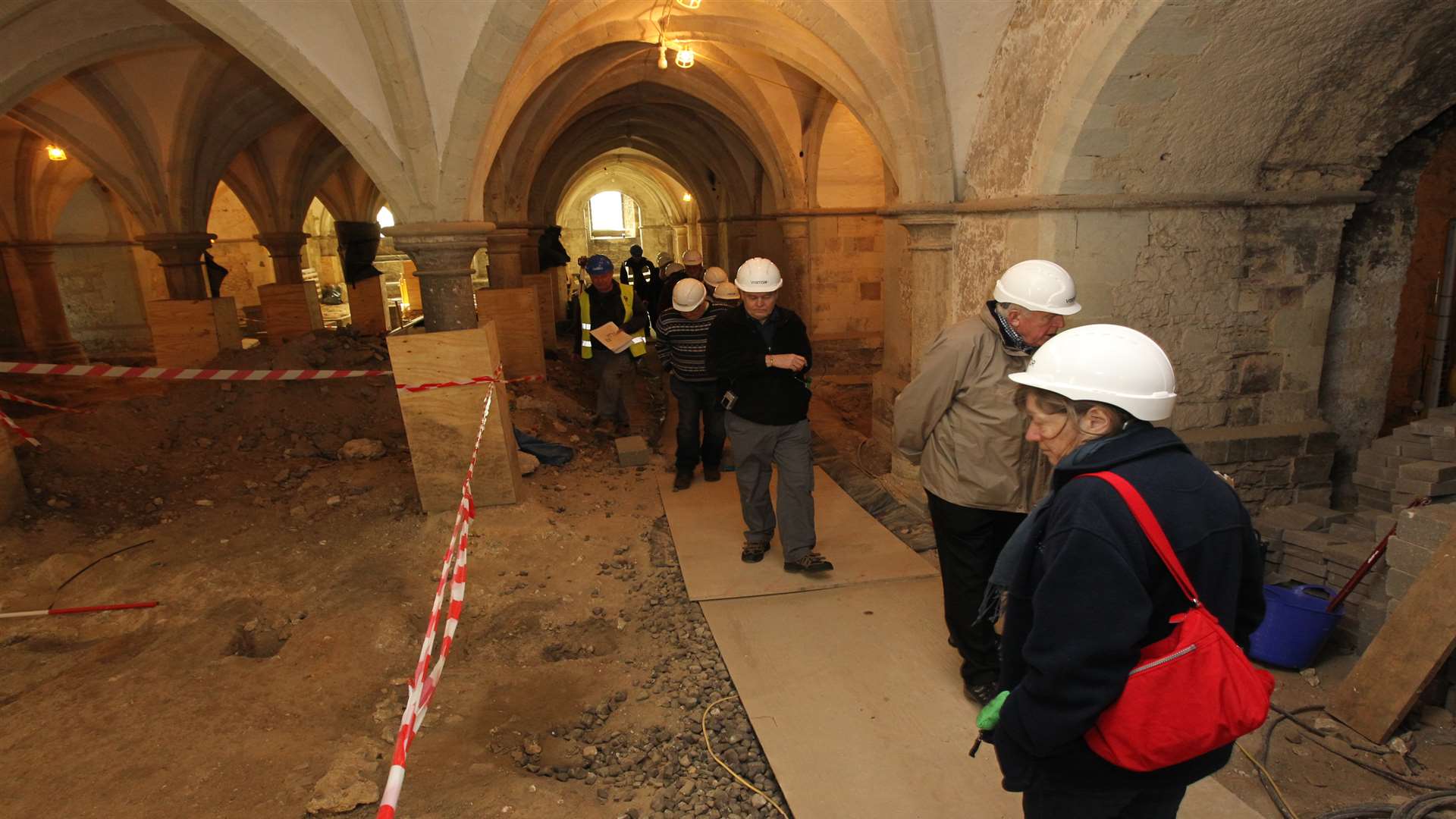 A tour group looking at excavation work in the crypt in Rochester Cathedral.