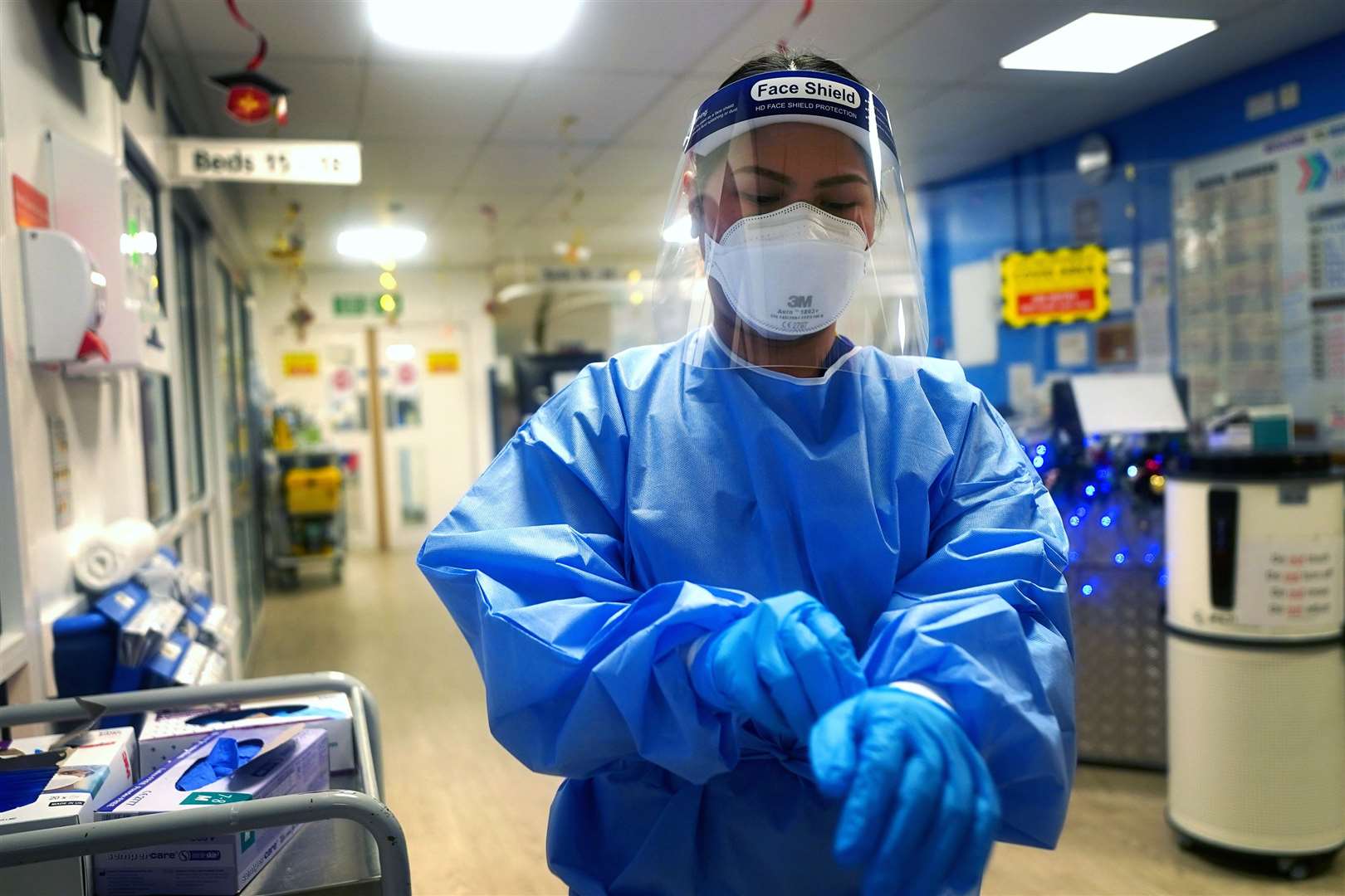 A nurse puts on full PPE (Victoria Jones/PA)