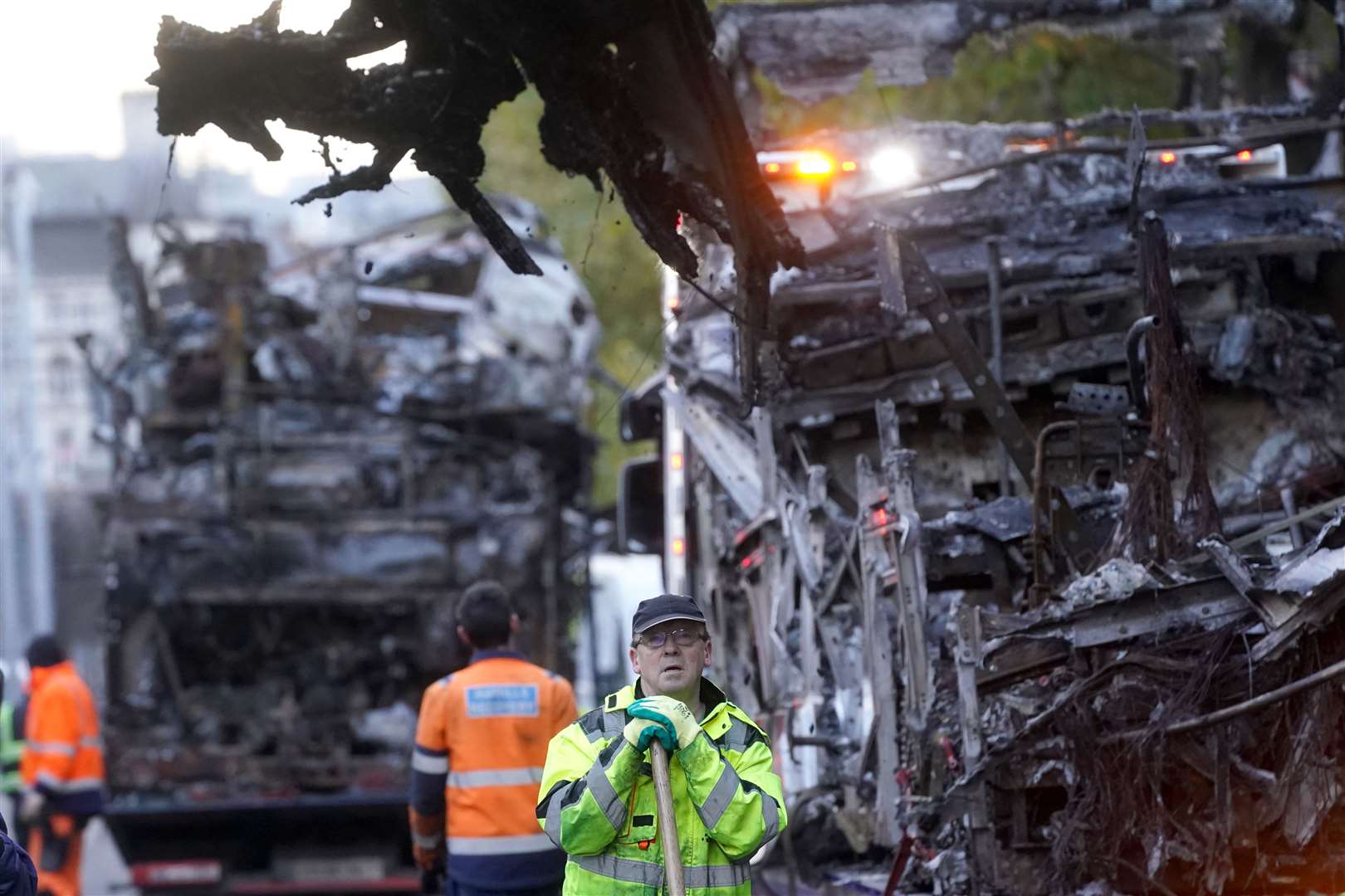 Workers cleared debris besides damaged public transport vehicles on O’Connell Street in Dublin in the aftermath of violent scenes in the city centre in November (Brian Lawless/PA)