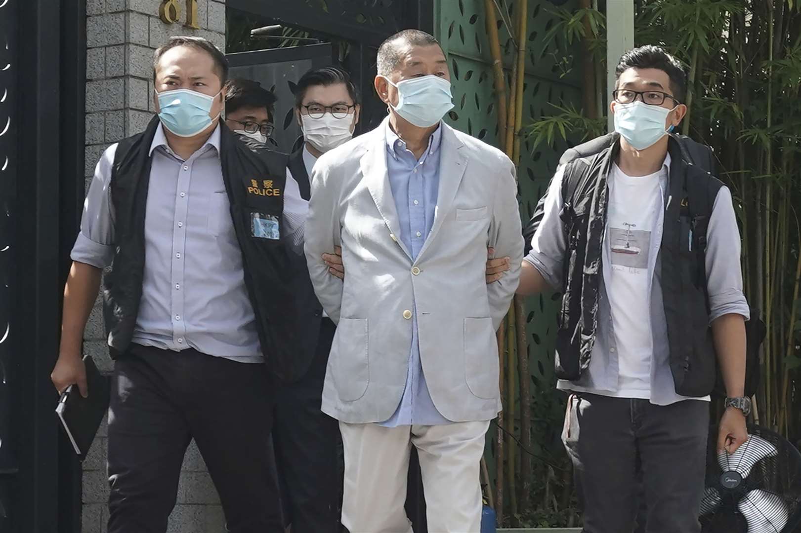 Hong Kong media tycoon Jimmy Lai is arrested by police officers at his home in Hong Kong (AP)