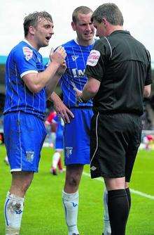 Gillingham midfielder Charlie Lee is booked against Morecambe