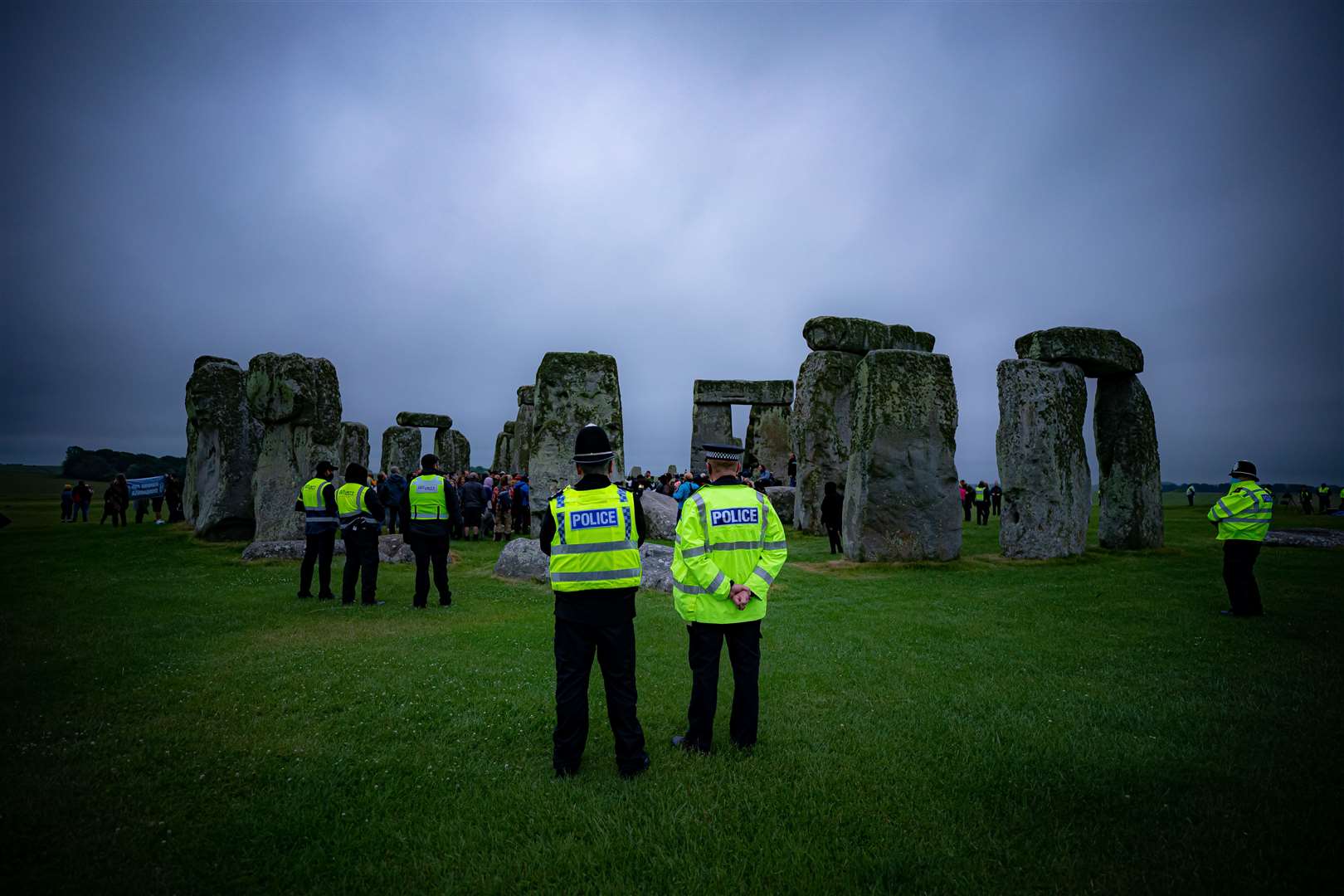 Police watch crowds celebrate Summer Solstice at Stonehenge (Ben Birchall/PA)