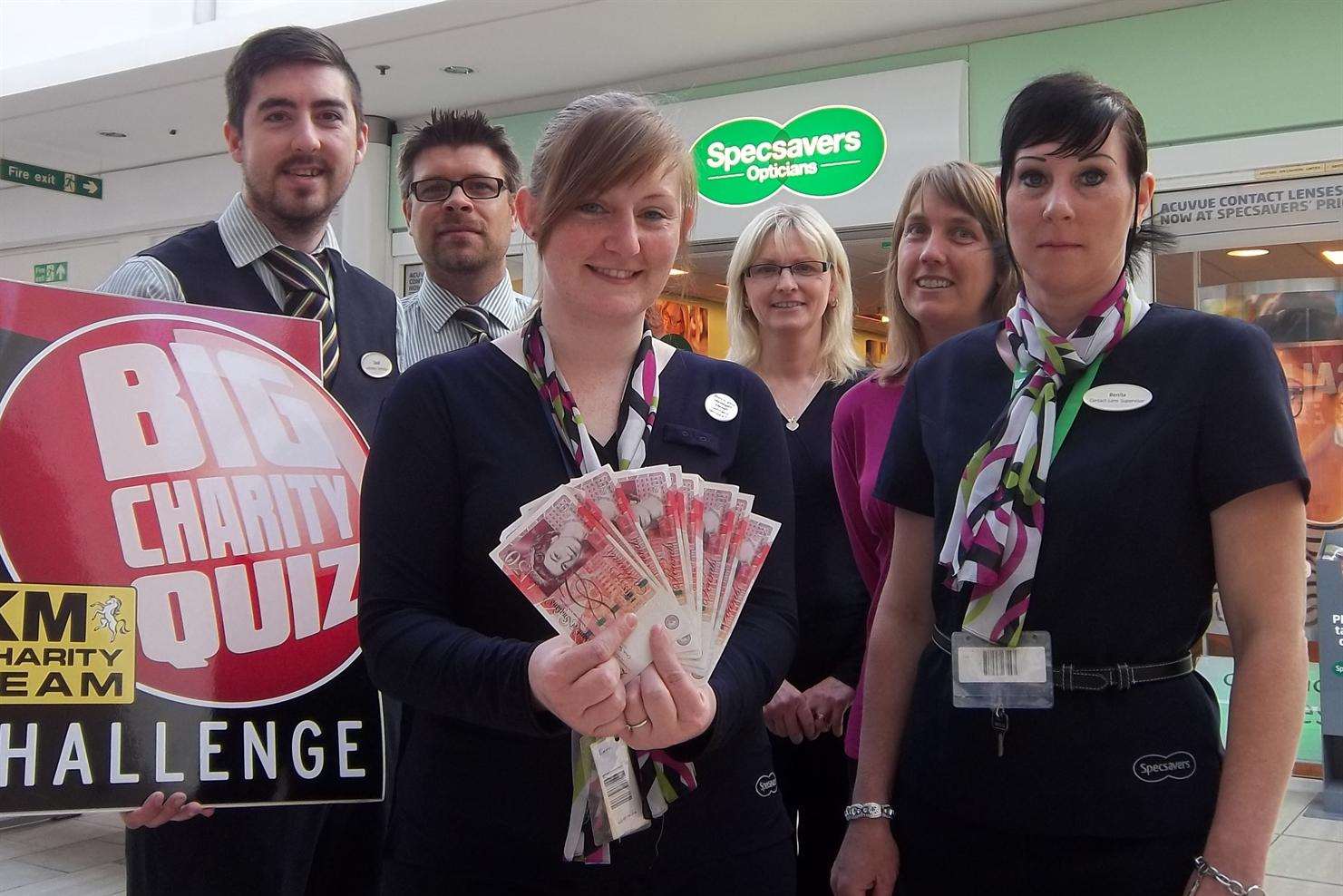 Specsavers store members from Ashford showing off the £500 which could be won at the KM Big Charity Quiz by one lucky person selected on the night to answer an on the spot quiz question